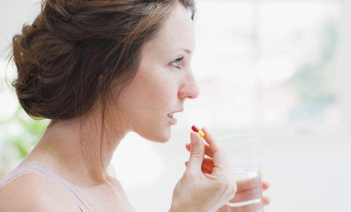 Женщина принимает противогрибковый препарат